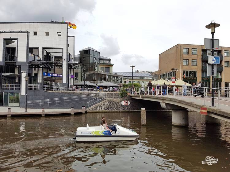 Casal passeando de pedalinho por um dos canais de Amsterdã